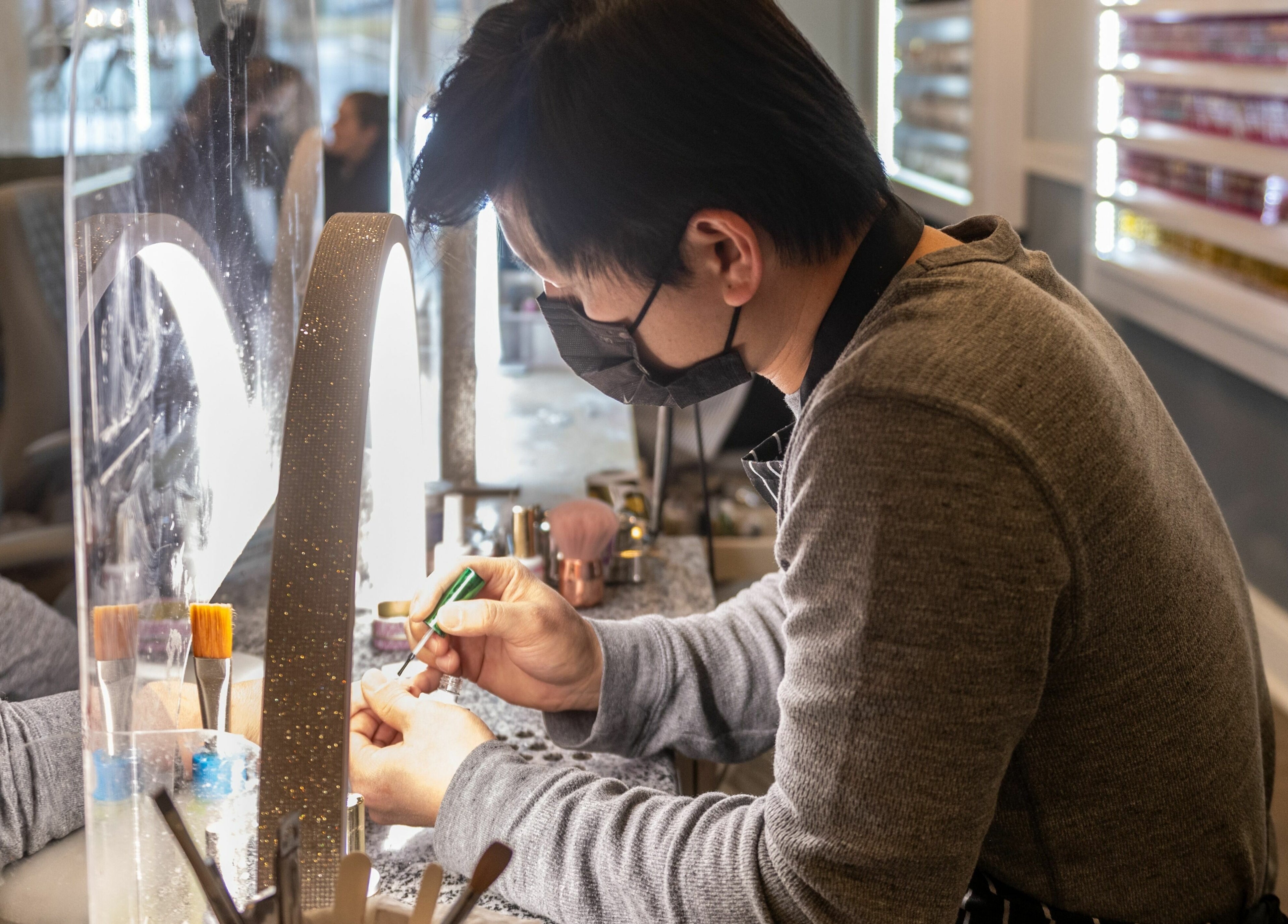 Nail technician at Nj Image Nails, Toms River, New Jersey, US, skillfully working on manicure.