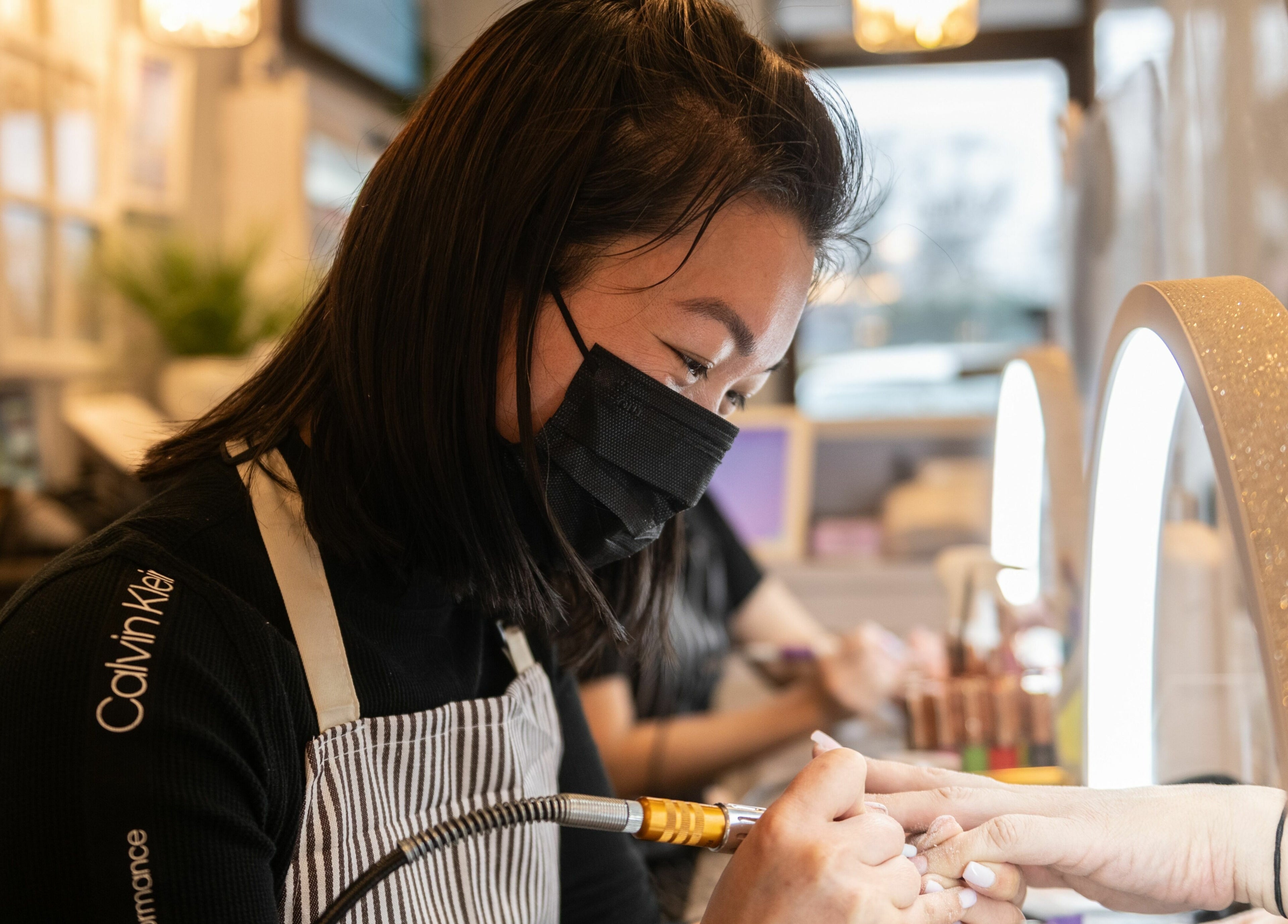A skilled nail technician working at Nj Image Nails in Toms River, New Jersey, US, performing a manicure.