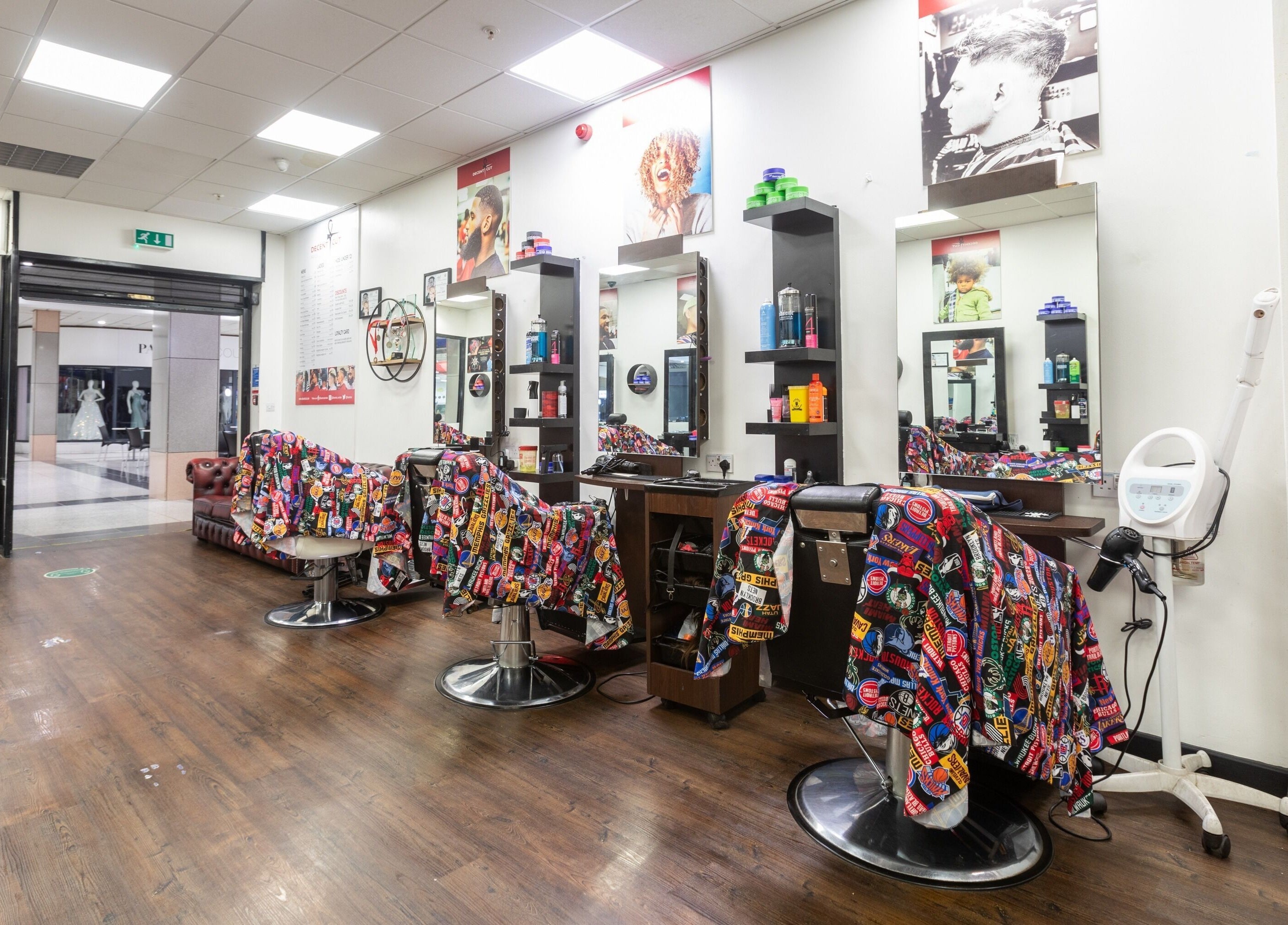 Bright, welcoming interior of Decent Cut salon in Manchester, England, GB showcasing colorful barber chairs.