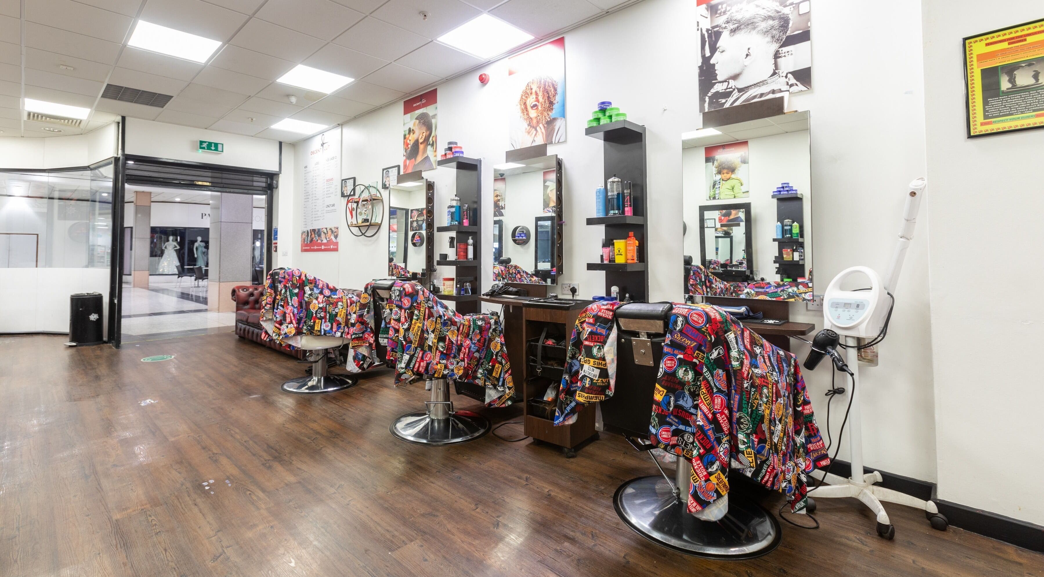 Bright, welcoming interior of Decent Cut salon in Manchester, England, GB showcasing colorful barber chairs.