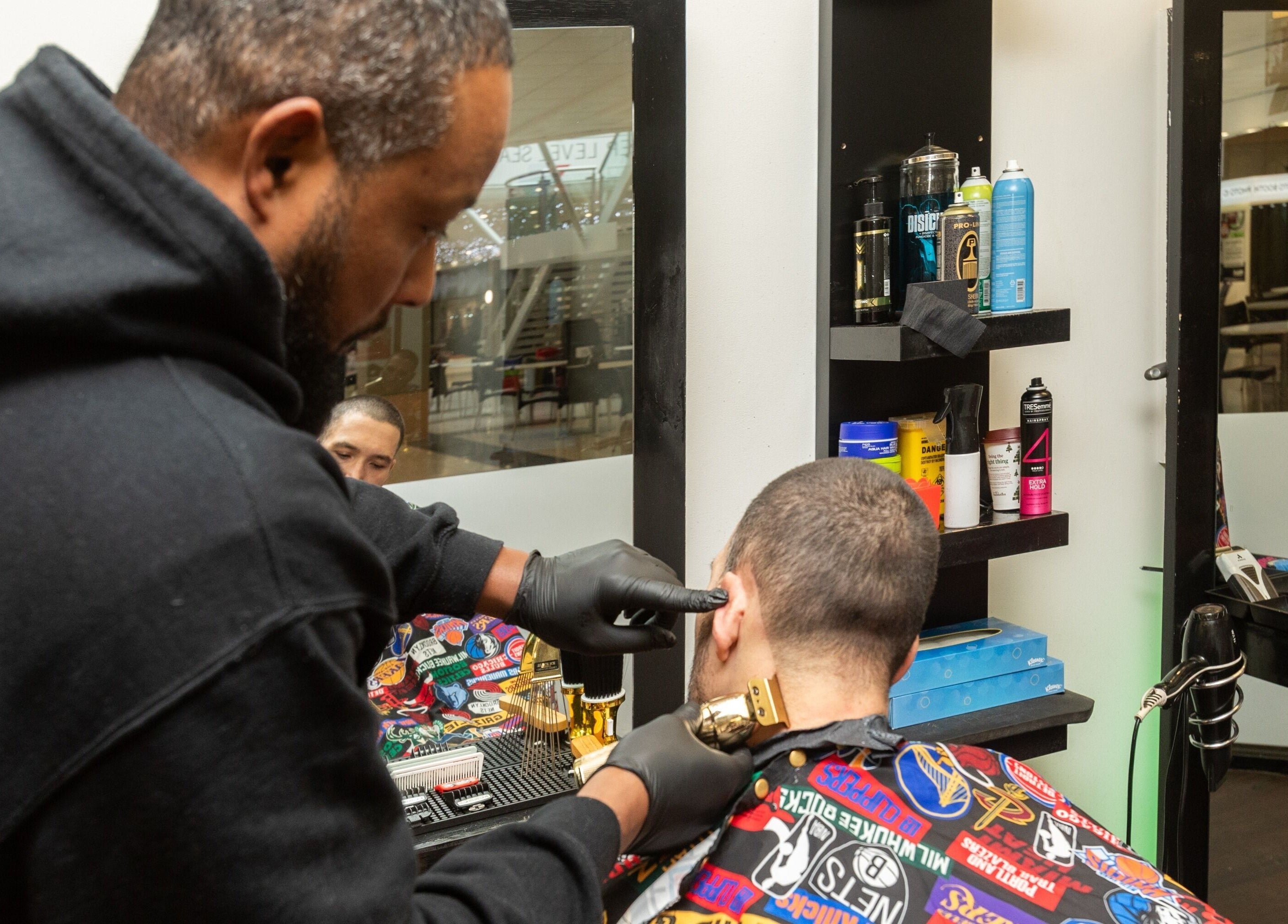 Barber at Decent Cut in Manchester, England, GB skillfully trims a client's hair.