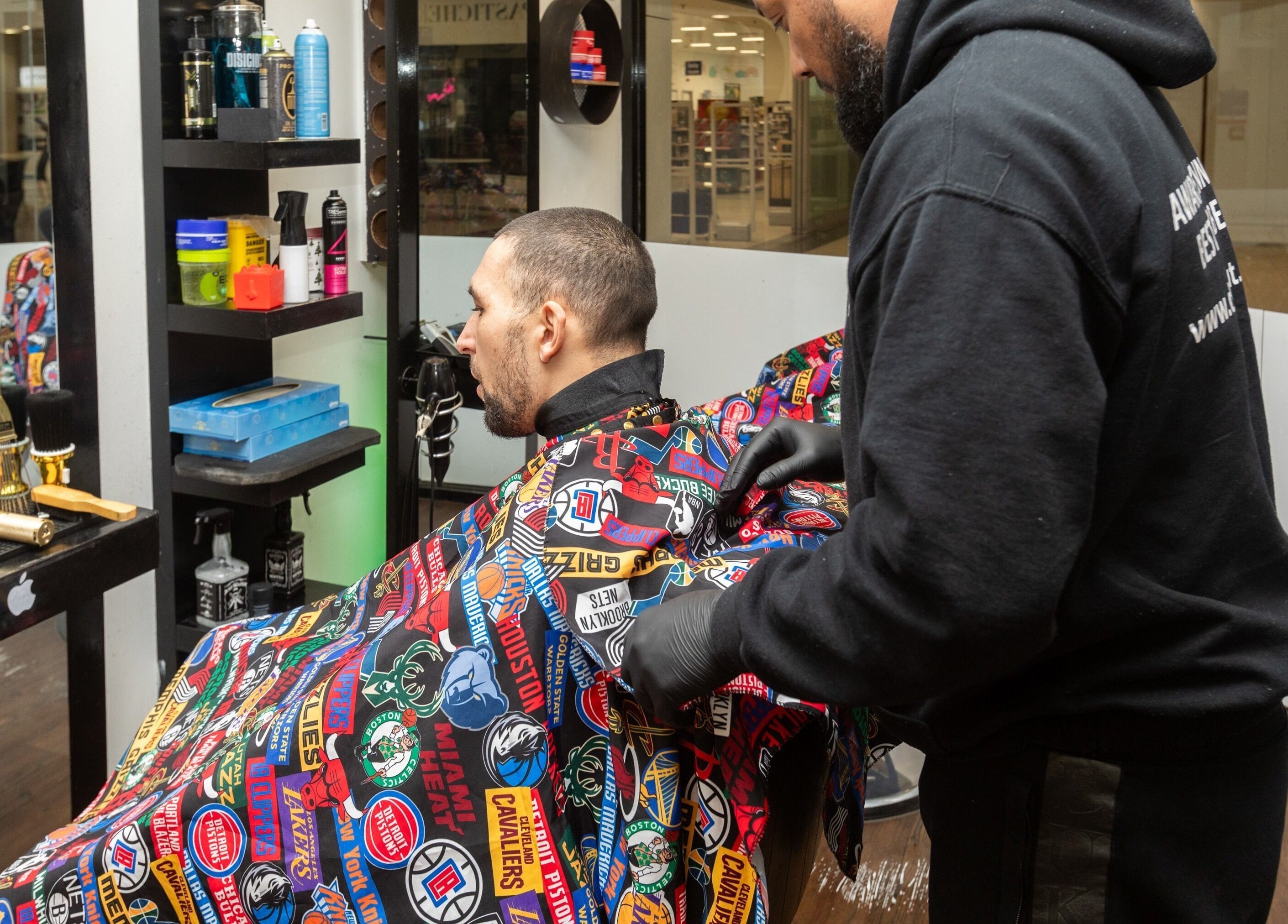 Barber styling a client at Decent Cut, a popular salon in Manchester, England, GB.