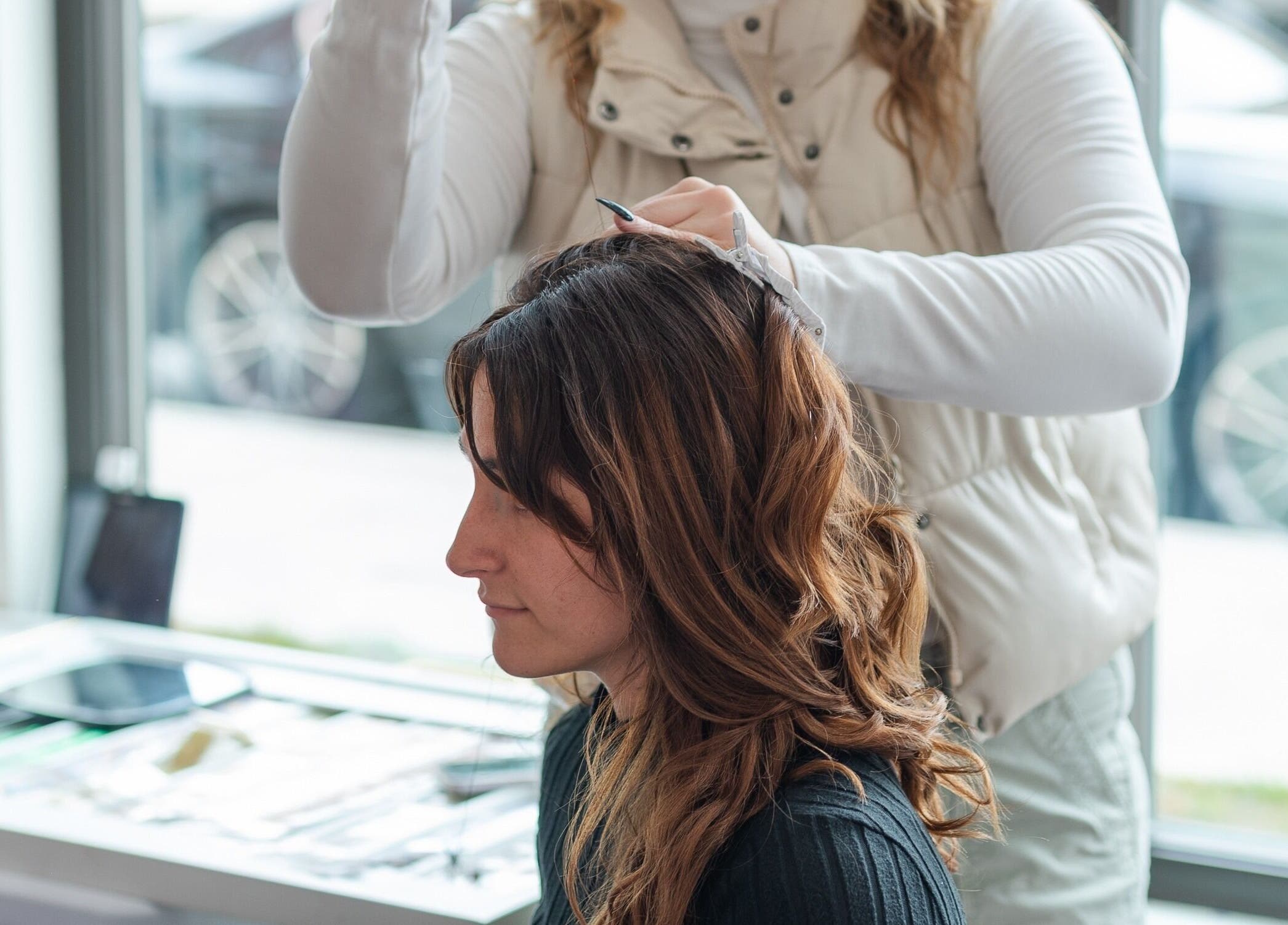 Stylist working on a client's hair at Twinkling Tresses Apollo Beach, Apollo Beach, Florida, US salon.