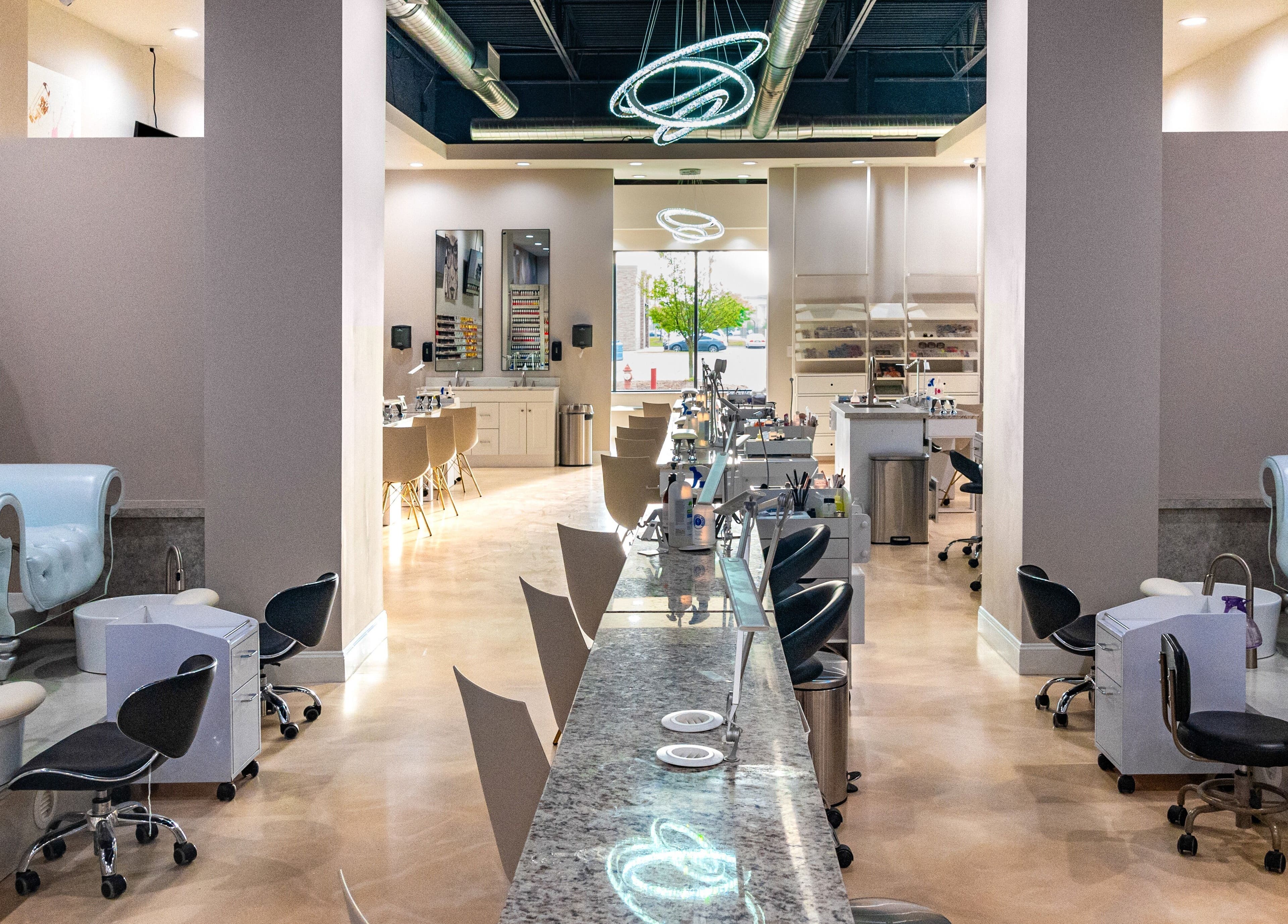 Gloss Nail Atelier in Sterling Heights, Michigan, US featuring stylish seating and modern nail stations.