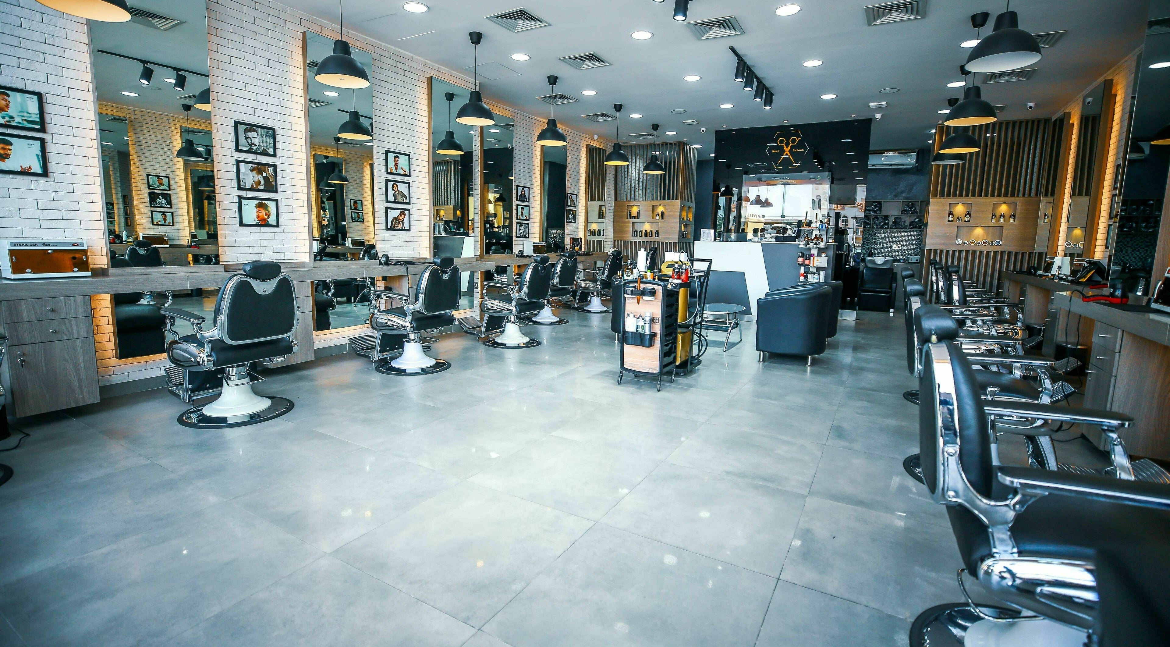 Spacious, modern interior of Ward Salon in Dubai, Dubai, AE with stylish black chairs and illuminated mirrors.