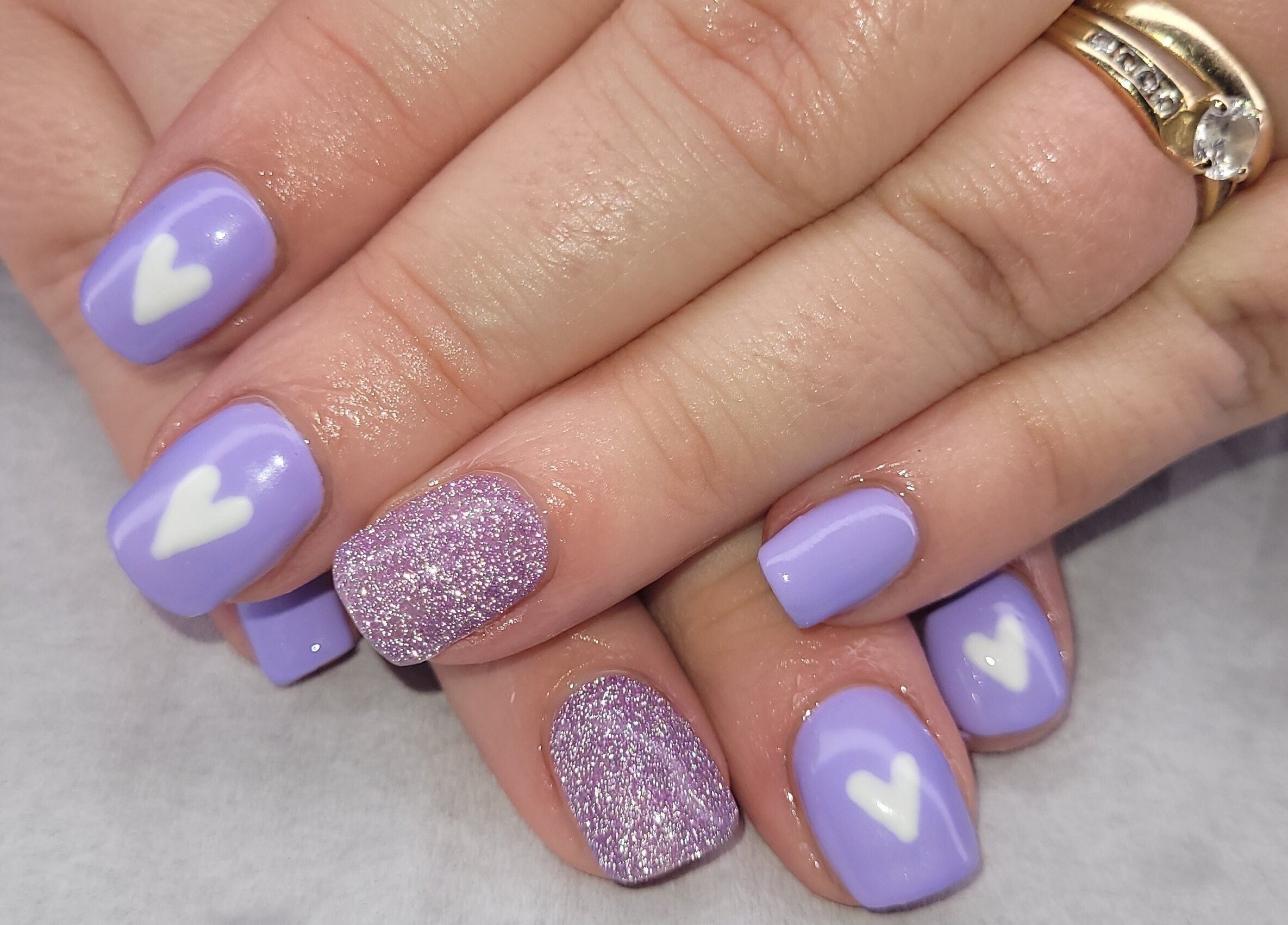 Lavender nails with white hearts and glitter at Beauty By Jo, Guiseley, England, GB.