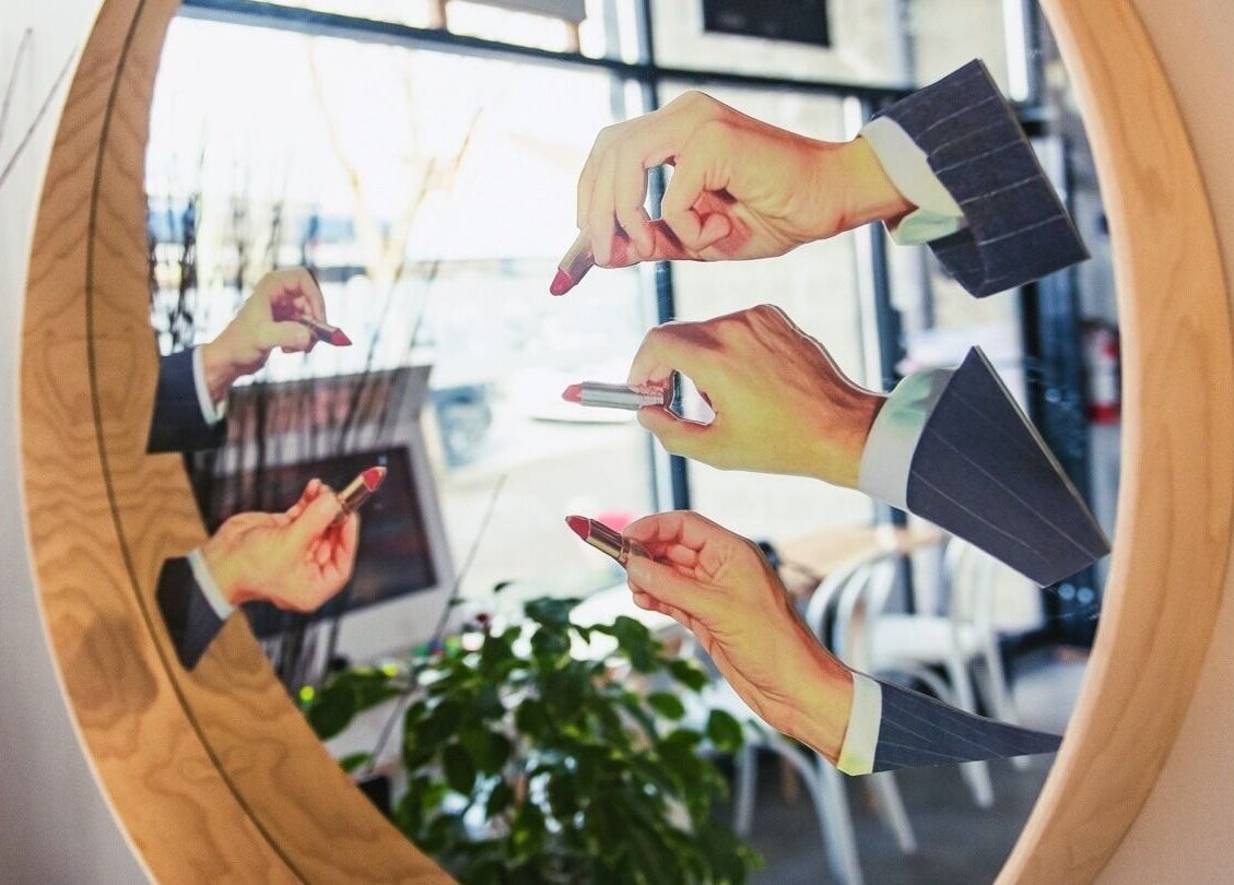 Multiple hands with lipstick reflected in a mirror at Amuse Hair and Nail Salon, Langley City, British Columbia, CA.
