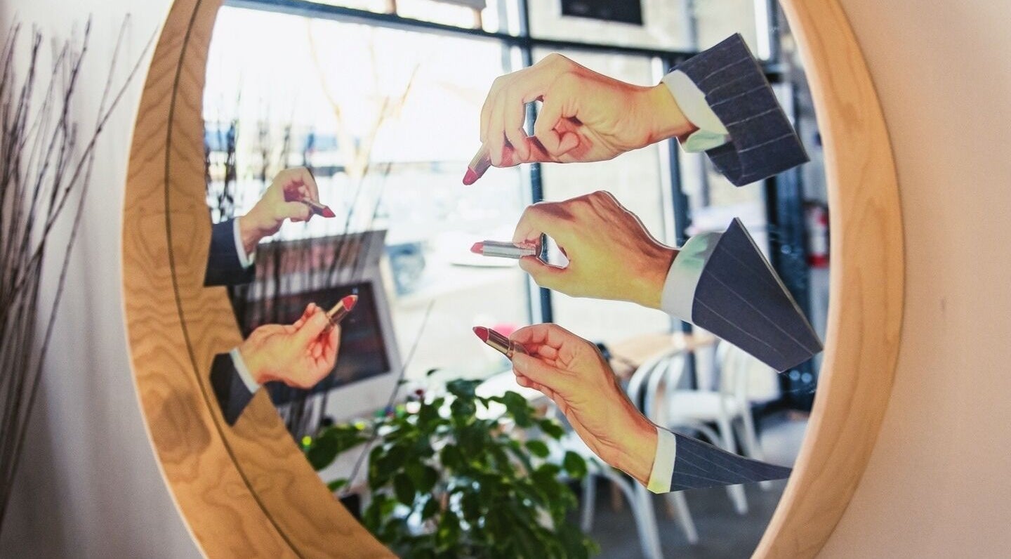 Multiple hands with lipstick reflected in a mirror at Amuse Hair and Nail Salon, Langley City, British Columbia, CA.