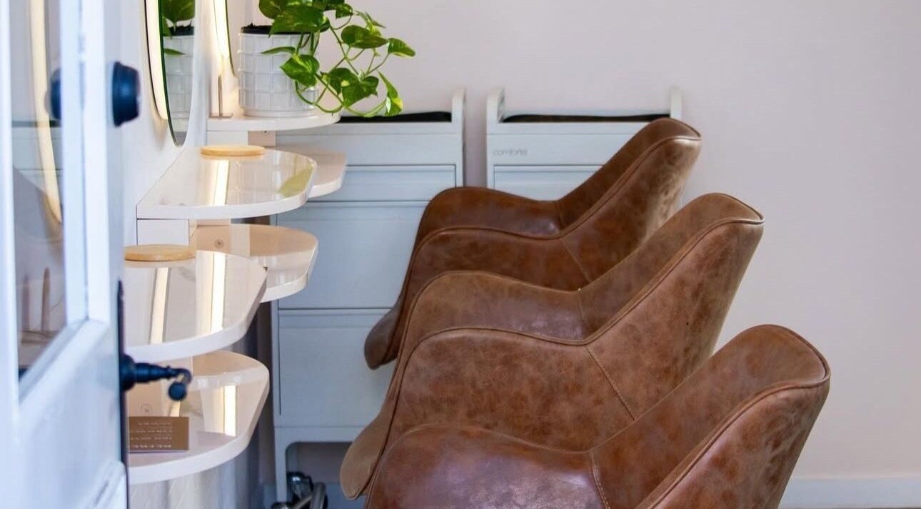 Stylish brown chairs at AoifeMariehairartistry salon in Brisbane, Queensland, AU with sleek design and greenery.