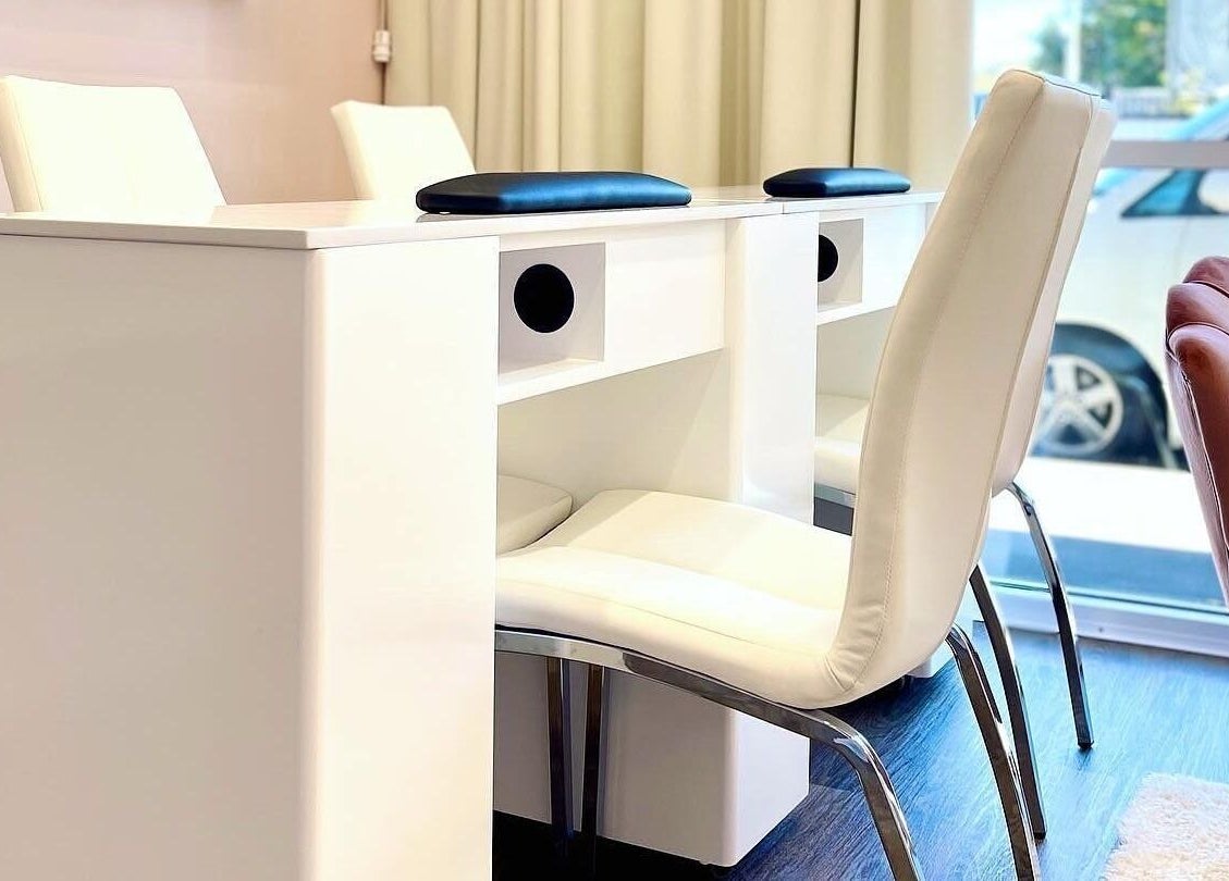 Bright nail salon area at Glowing Goddess Beauty, Christchurch, Canterbury, NZ with modern white seating.