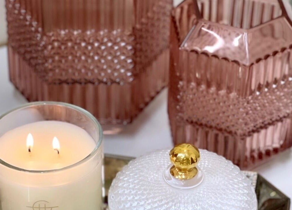 Elegant candle and pink glass decor at Glowing Goddess Beauty, Christchurch, Canterbury, NZ.