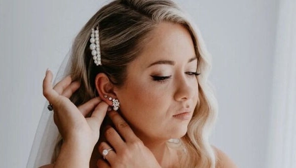 Bride adjusts earrings at Labelleame Aesthetics, Corindi Beach, New South Wales, AU.