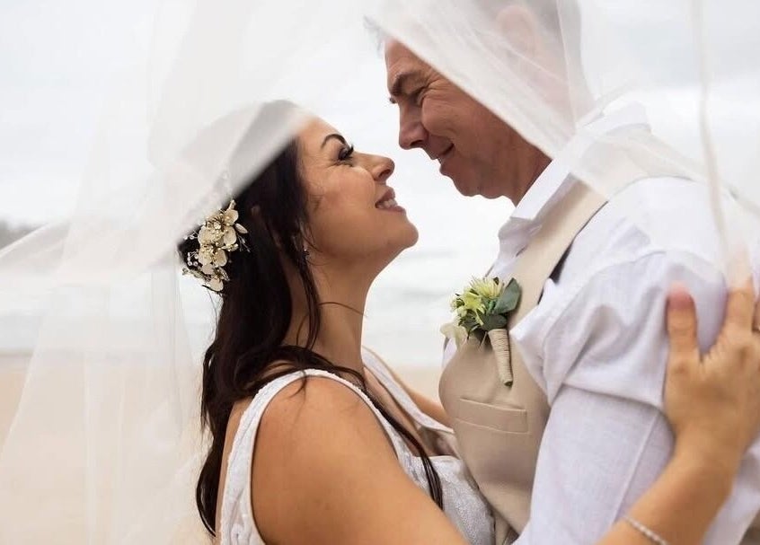 A couple embraces under a veil at Labelleame Aesthetics, Corindi Beach, New South Wales, AU.