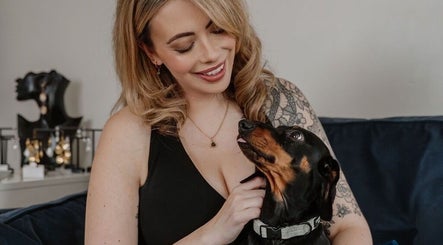 Person with a tattoo smiling at a dog in AbiLou Beauty, Stowmarket, England, GB.