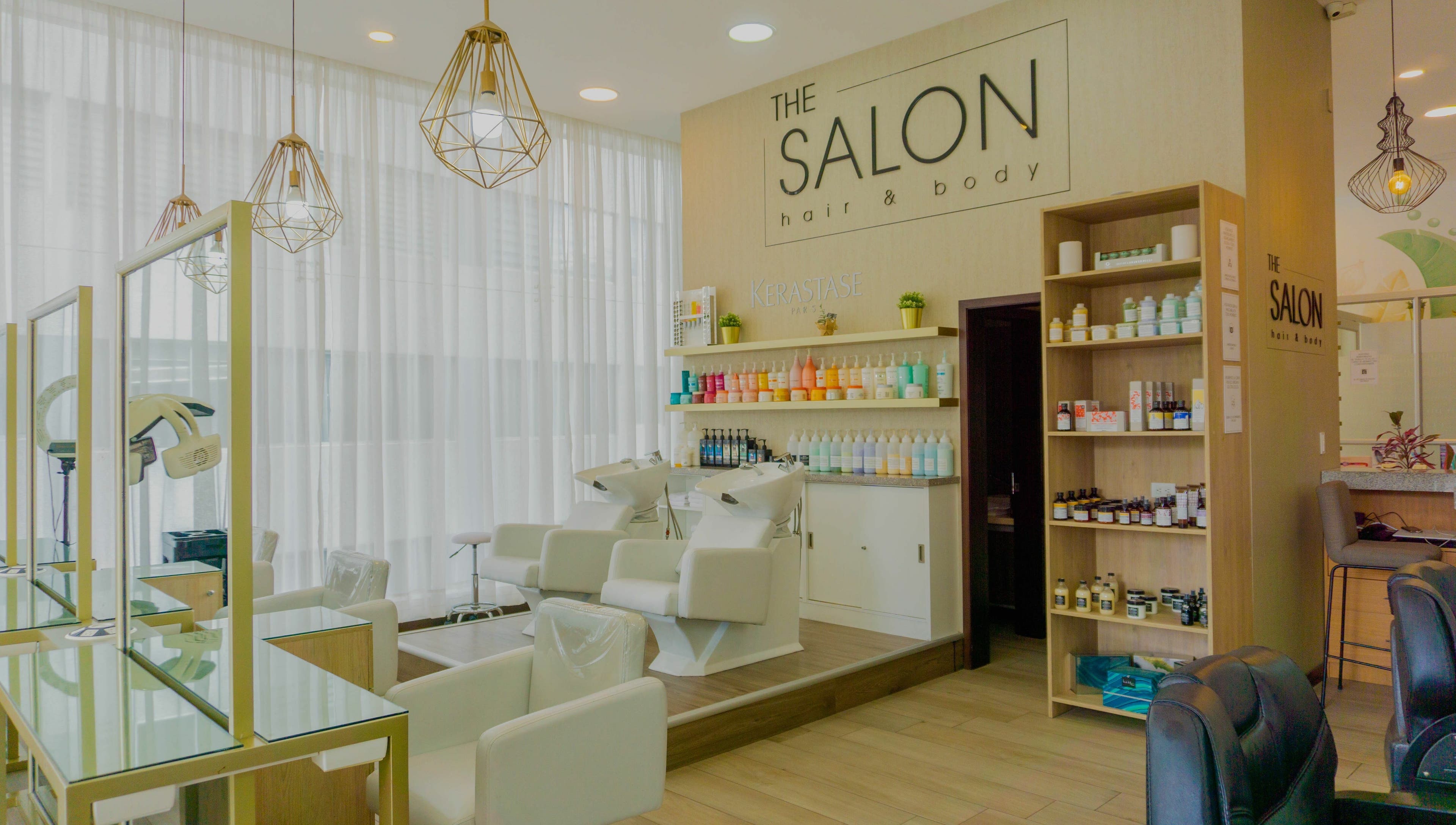 Interior elegante de The Salon en Quito, Pichincha, EC, con sillas blancas y productos profesionales de belleza.