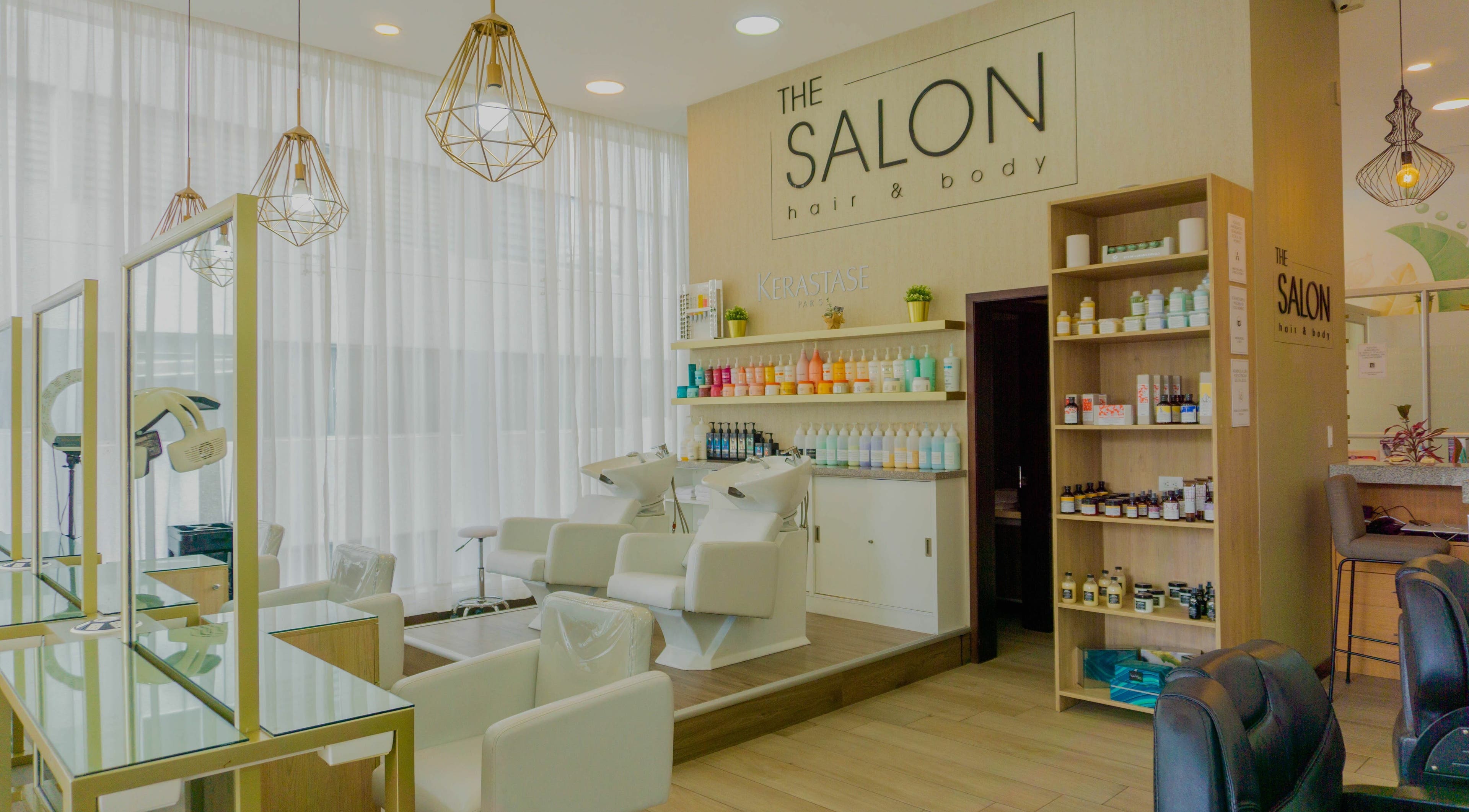 Interior elegante de The Salon en Quito, Pichincha, EC, con sillas blancas y productos profesionales de belleza.