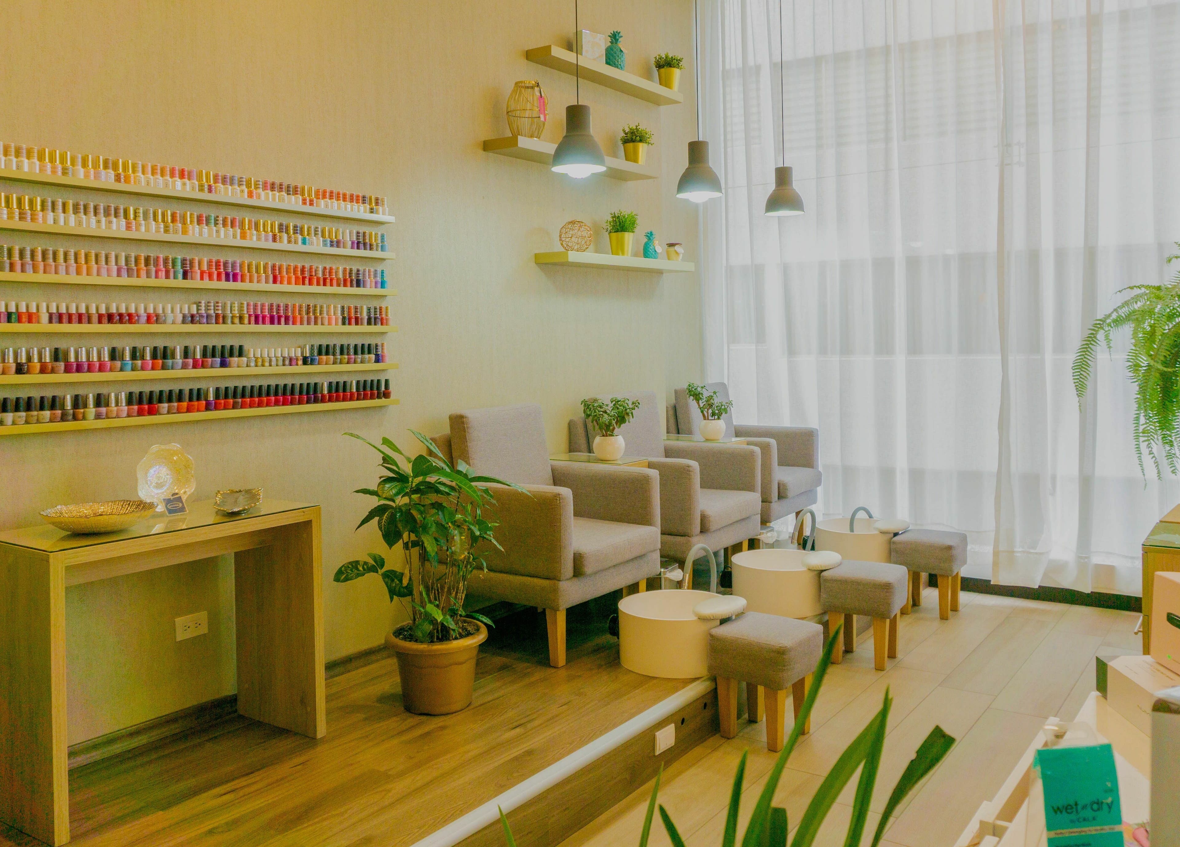 Área de manicura en The Salon, Quito, Pichincha, EC, con sillas cómodas y estantes de esmaltes.