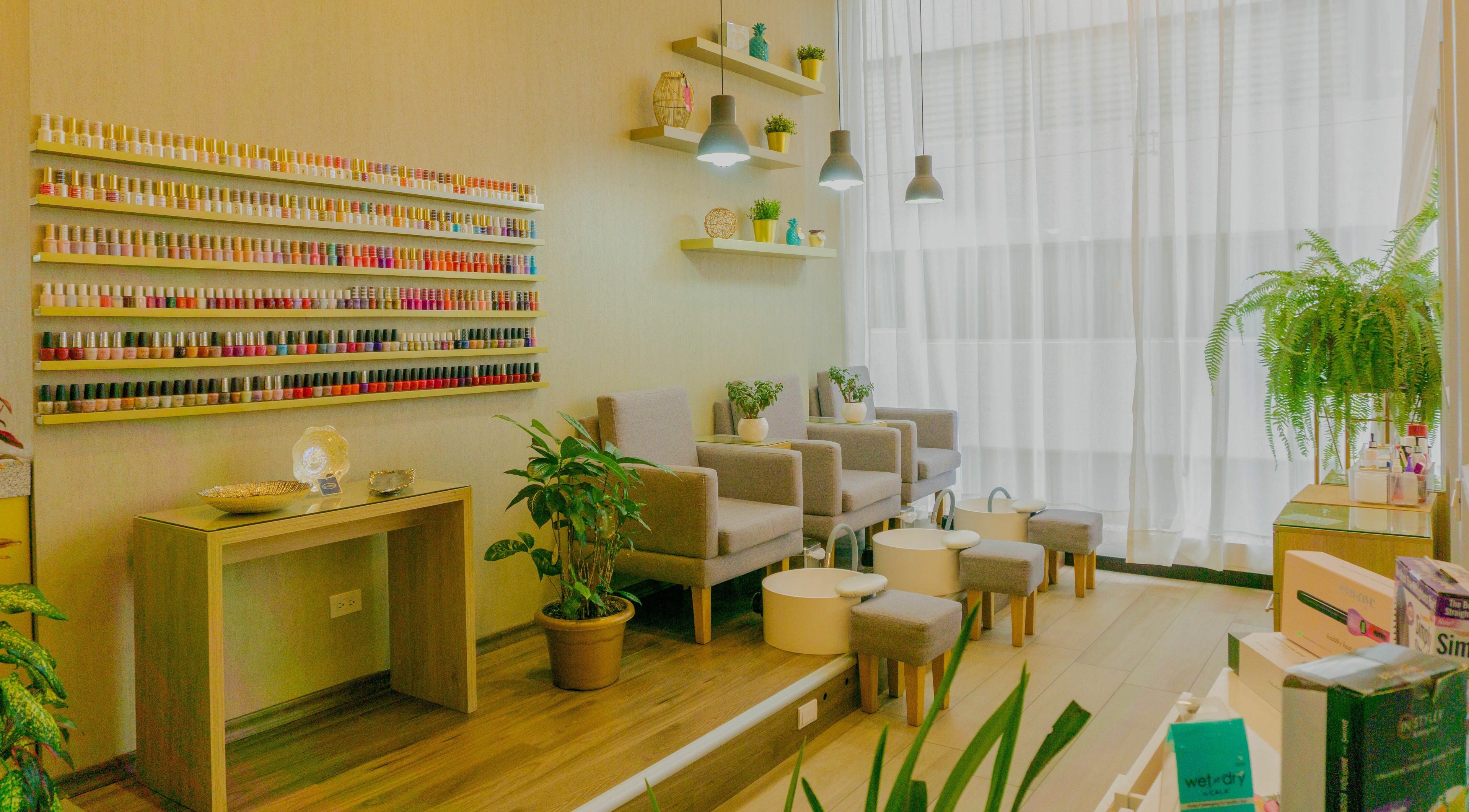 Área de manicura en The Salon, Quito, Pichincha, EC, con sillas cómodas y estantes de esmaltes.