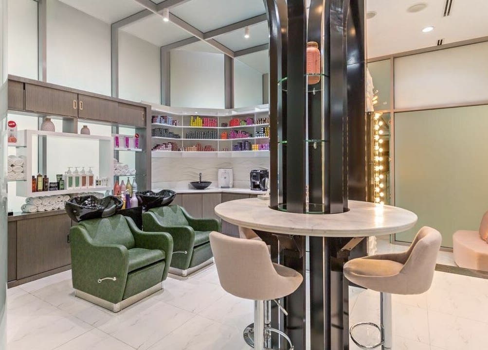 Modern beauty setup at Ricci Capricci, Dubai. Luxurious salon with stylish chairs and shelves full of products.