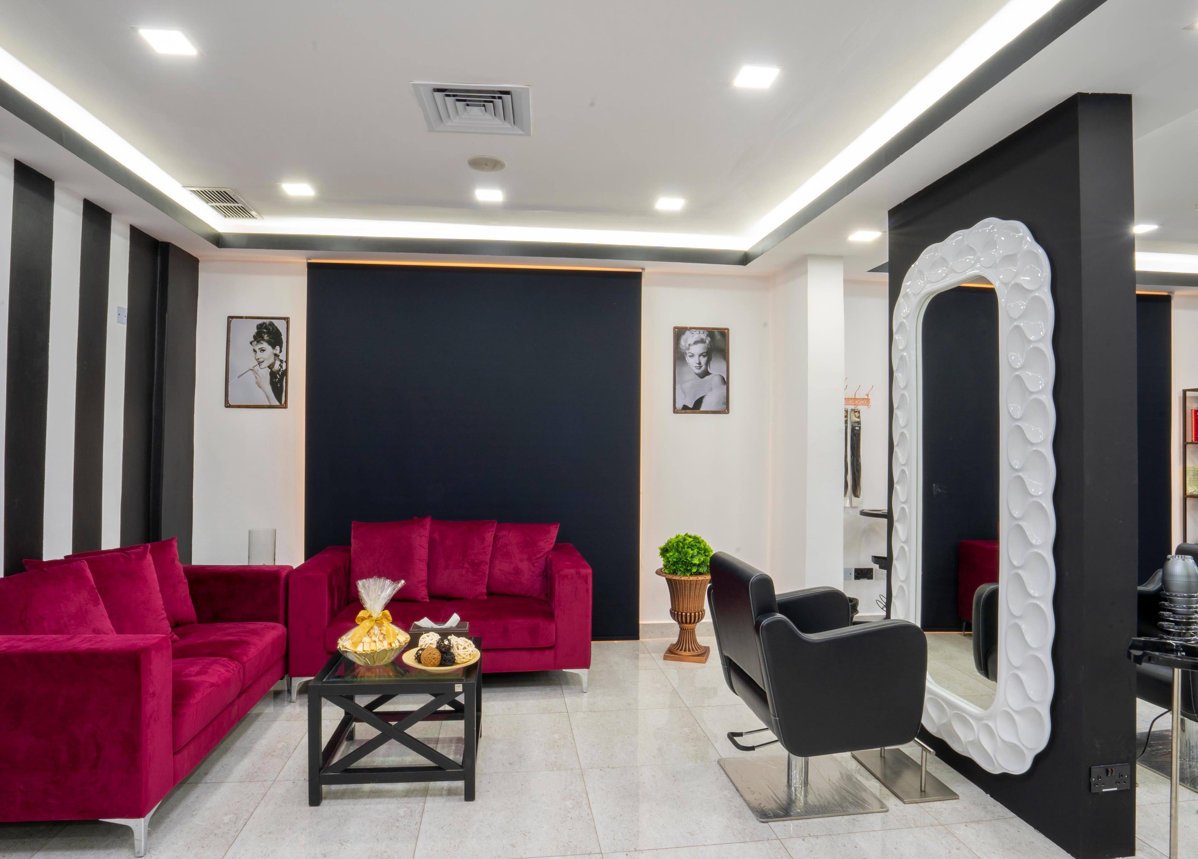 Sophisticated lounge at Beauty Lounge, Salmiya, Hawalli Governorate, KW with vibrant red sofas and modern décor.