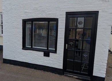 The entrance of Amara's Hair Lounge, Exning, England, GB featuring a stylish black door and window.