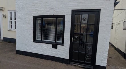 The entrance of Amara's Hair Lounge, Exning, England, GB featuring a stylish black door and window.