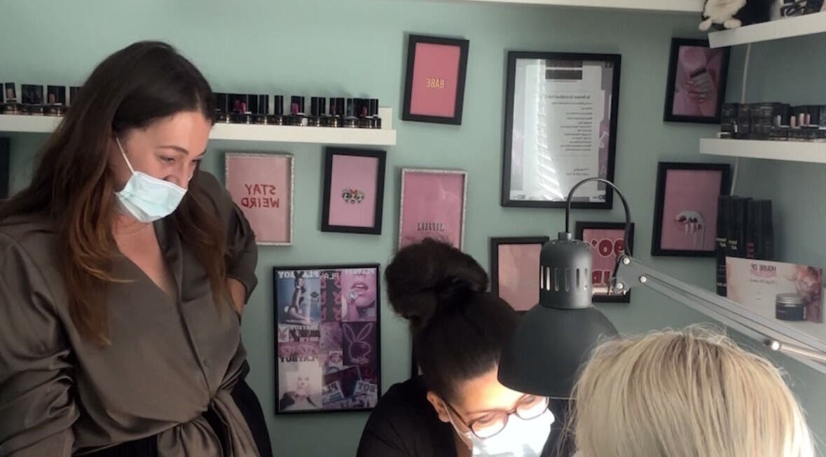 Stylists at HON Nail Academy in Mountsorrel, England, GB, working on nail art under bright lighting.