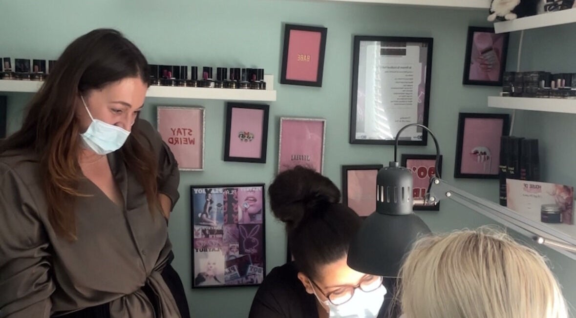 Stylists at HON Nail Academy in Mountsorrel, England, GB, working on nail art under bright lighting.