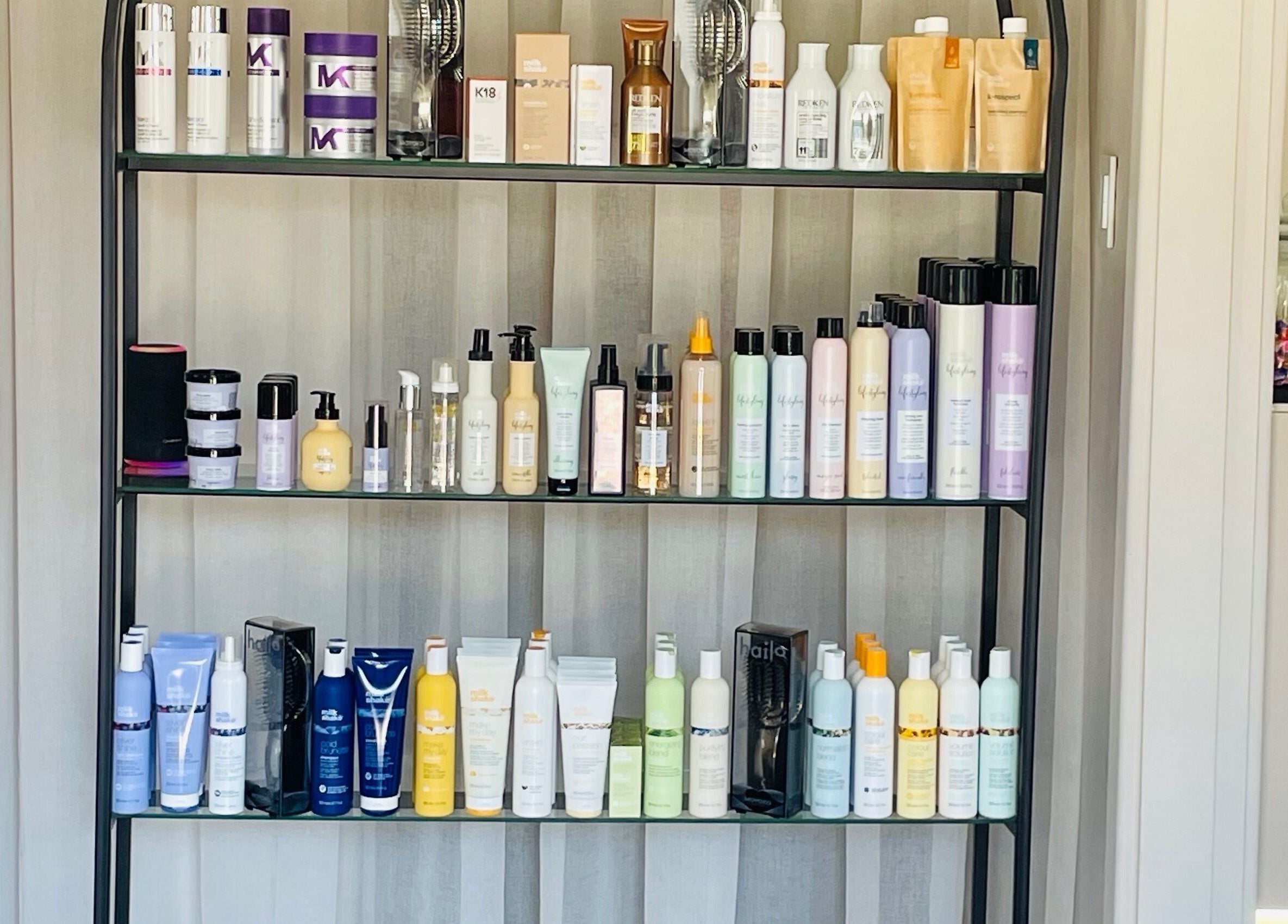 Beauty products at STATIC Dry Bar in Durban North, Kwazulu-natal, ZA, neatly arranged on a sleek shelf.