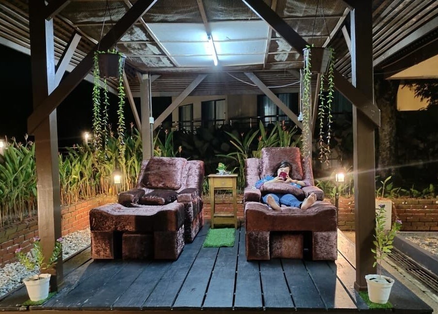 Cozy lounge area at night in Impiana Kuantan, Kuantan, Pahang, MY, featuring plush chairs and lush greenery.