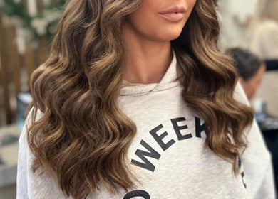 Woman with glam wavy hairstyle at De La Mare in North Lanarkshire, UK, GB salon setting.