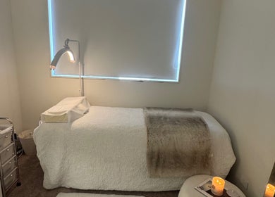 Cozy treatment room at Lash L'amour, Whangaparāoa, Auckland, NZ, featuring a plush bed and soothing lighting.