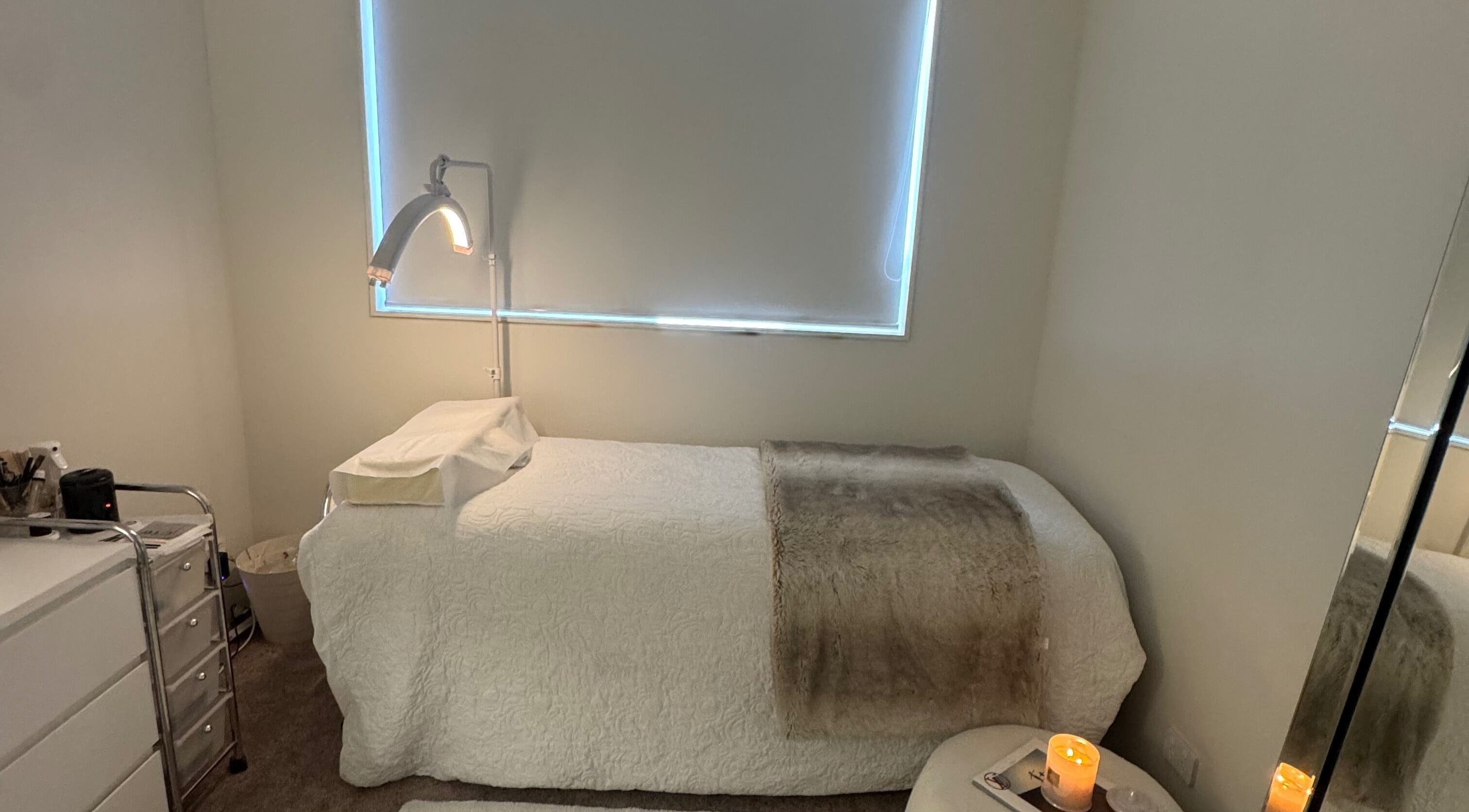 Cozy treatment room at Lash L'amour, Whangaparāoa, Auckland, NZ, featuring a plush bed and soothing lighting.