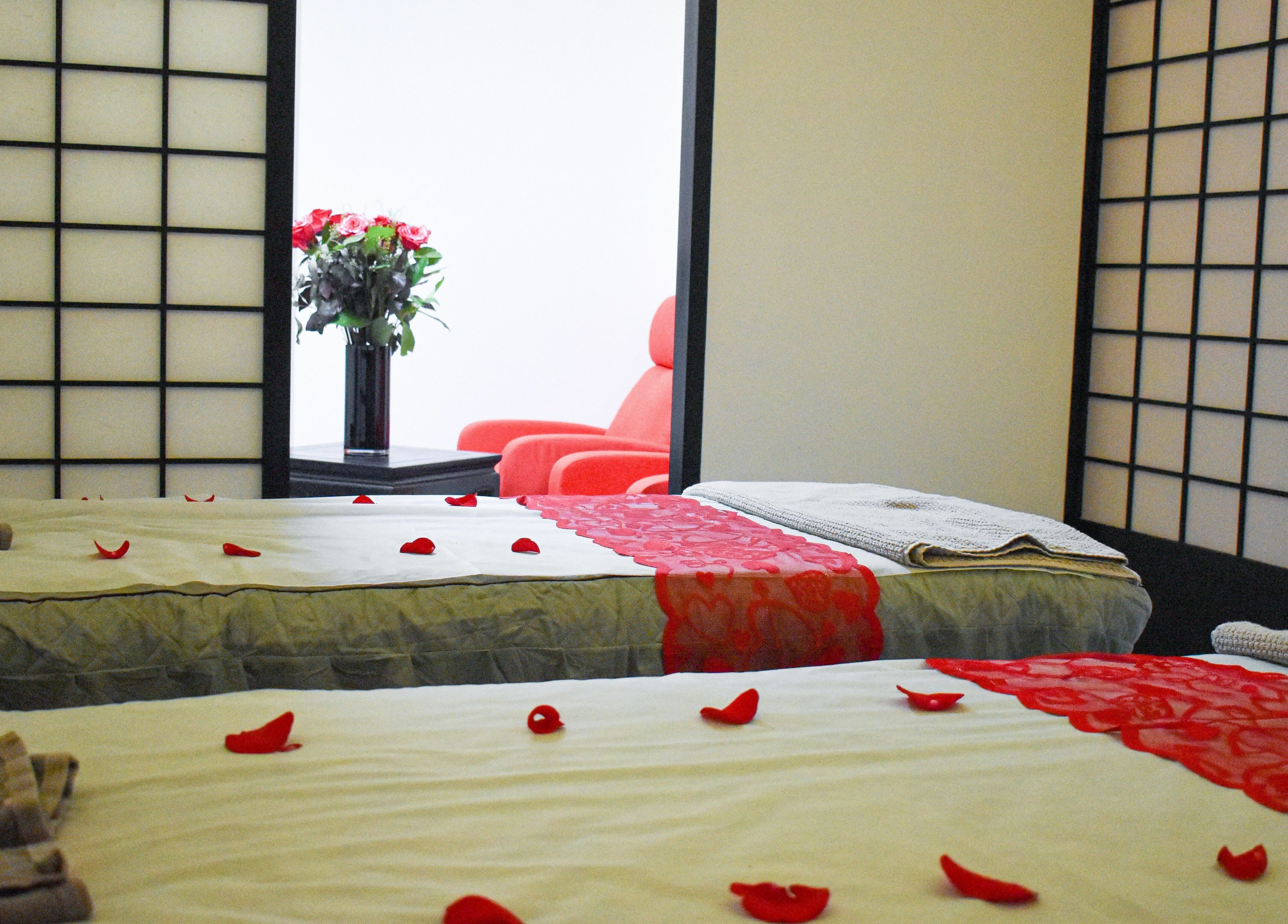 Relaxing spa room at The Couple Spa, New York, New York, US with petal-strewn massage beds.