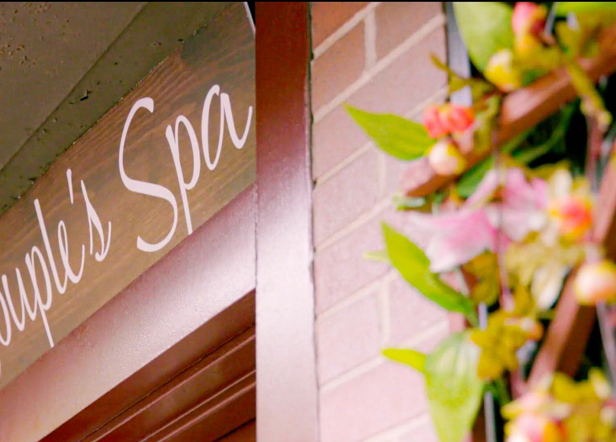 Entrance sign of The Couple Spa adorned with flowers, located in New York, New York, US.