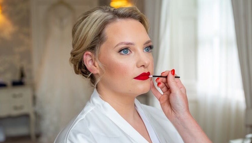 Makeup artist applying red lipstick at Shawndelle Scott Make Up Artistry in Musselburgh, Scotland, GB.