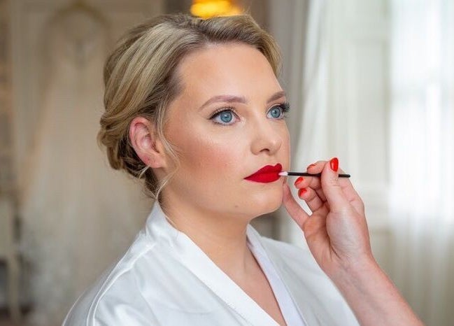 Makeup artist applying red lipstick at Shawndelle Scott Make Up Artistry in Musselburgh, Scotland, GB.