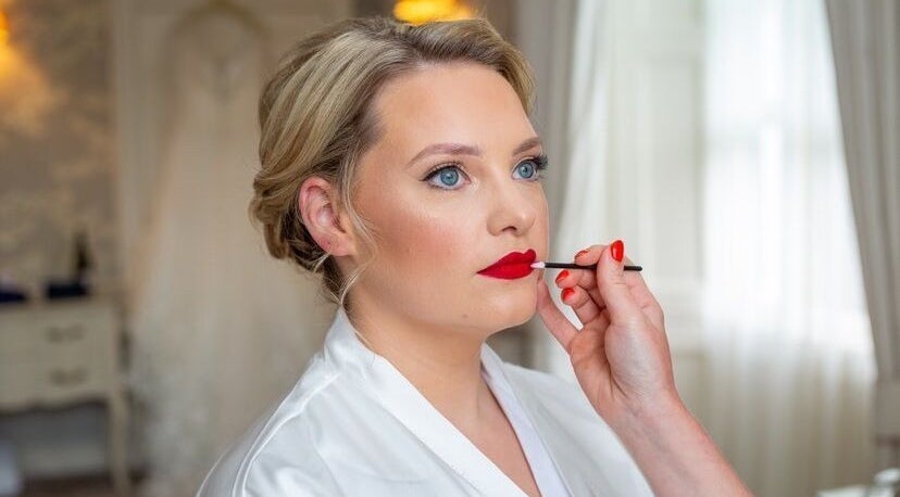 Makeup artist applying red lipstick at Shawndelle Scott Make Up Artistry in Musselburgh, Scotland, GB.