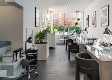 Interior of Salon Mari Chiswick in London, England, GB, featuring modern nail stations and cozy seating.