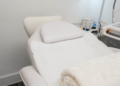 Treatment room at The Cure Clinic, London, England, GB, showcasing a comfortable spa bed and skincare equipment.