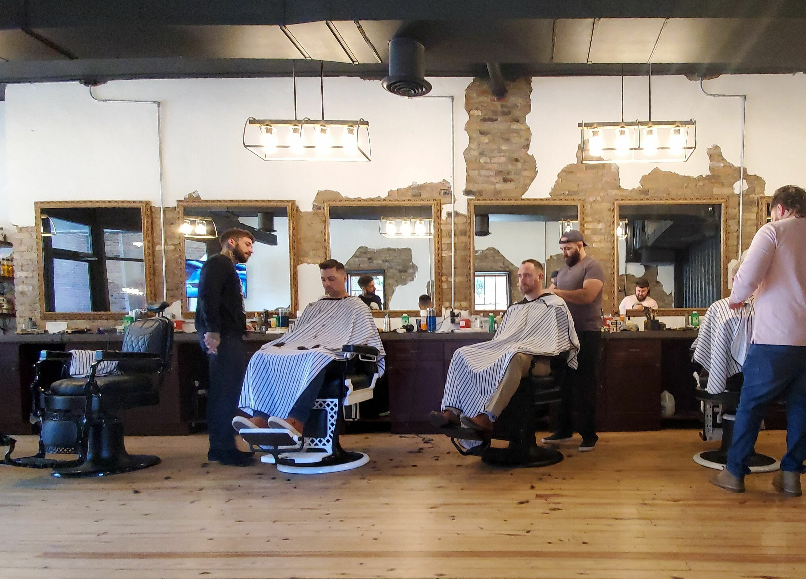 Stylish interior of Public Square Barbers in Gallatin, Tennessee, US with clients and barbers at work.