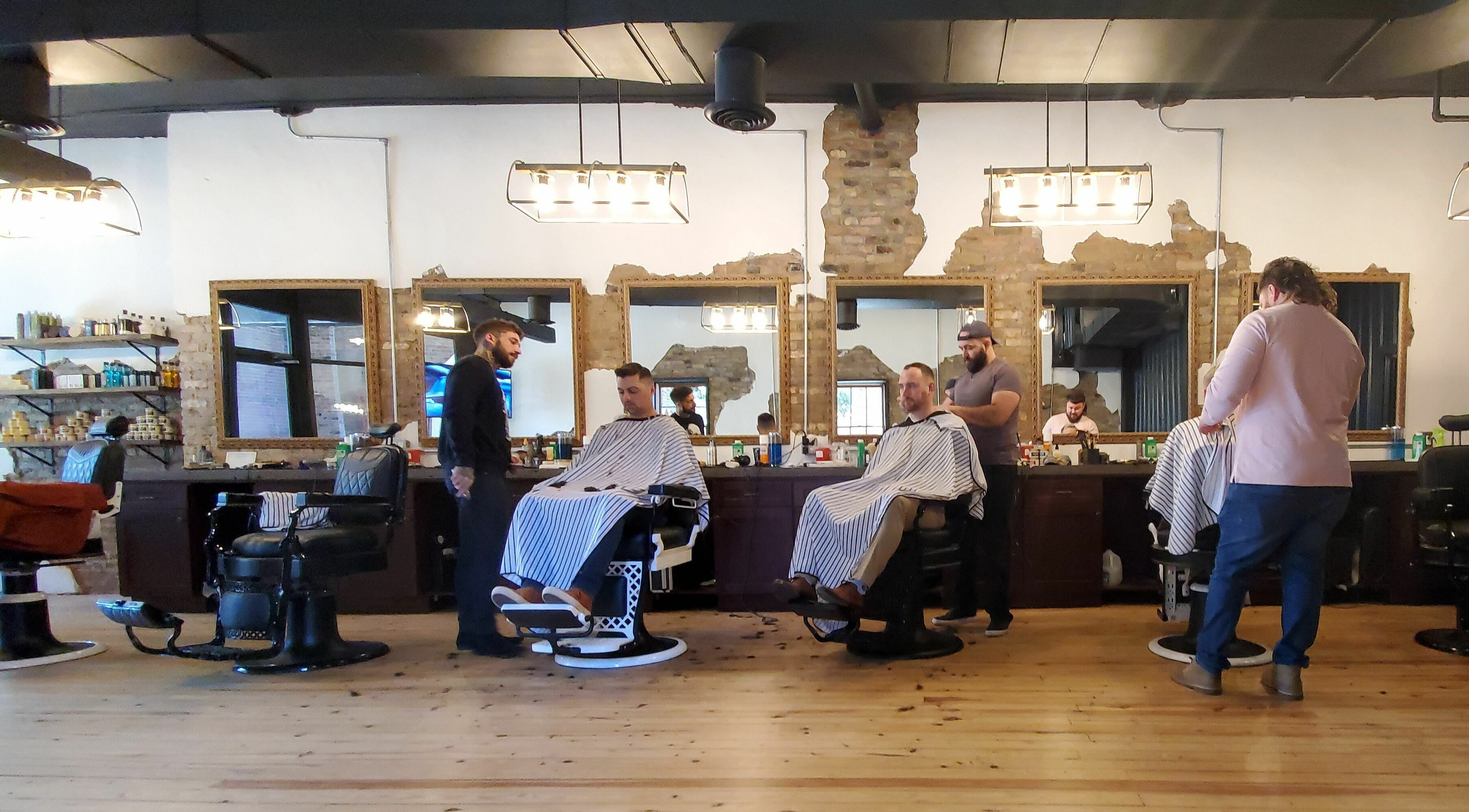Stylish interior of Public Square Barbers in Gallatin, Tennessee, US with clients and barbers at work.