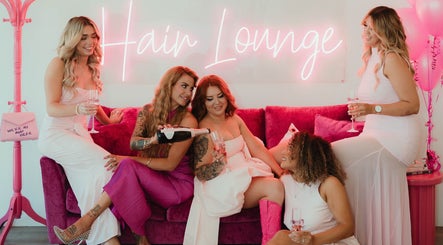 Ladies enjoying champagne at Lush Lane Hair Lounge, Bunbury, WA, AU, under neon lights.