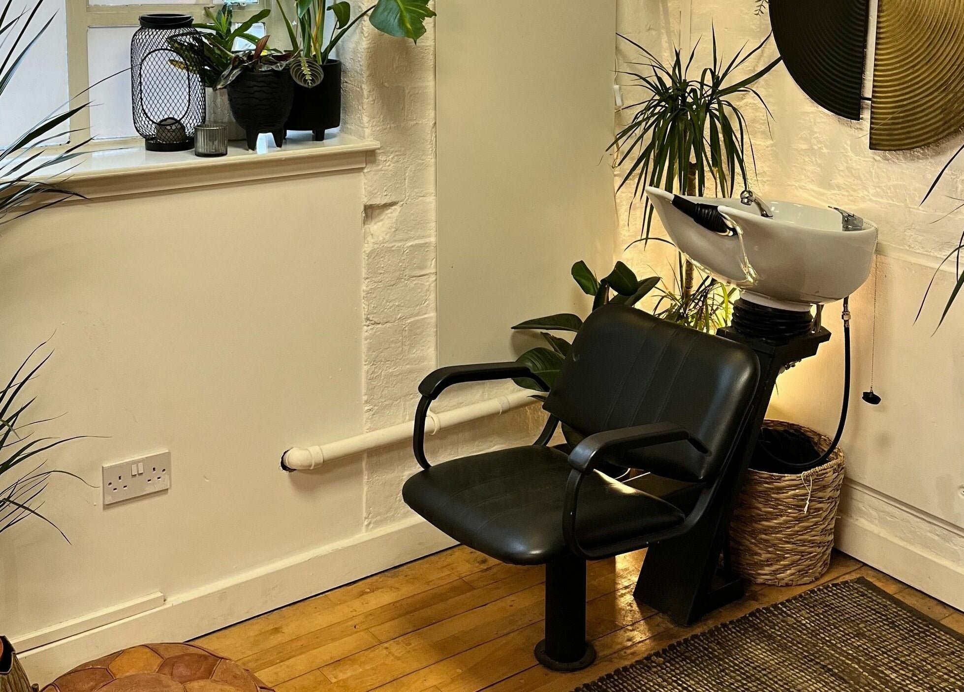 Stylish waiting area at Sheep Hair, Glasgow, Scotland, GB with lush plants and elegant decor.
