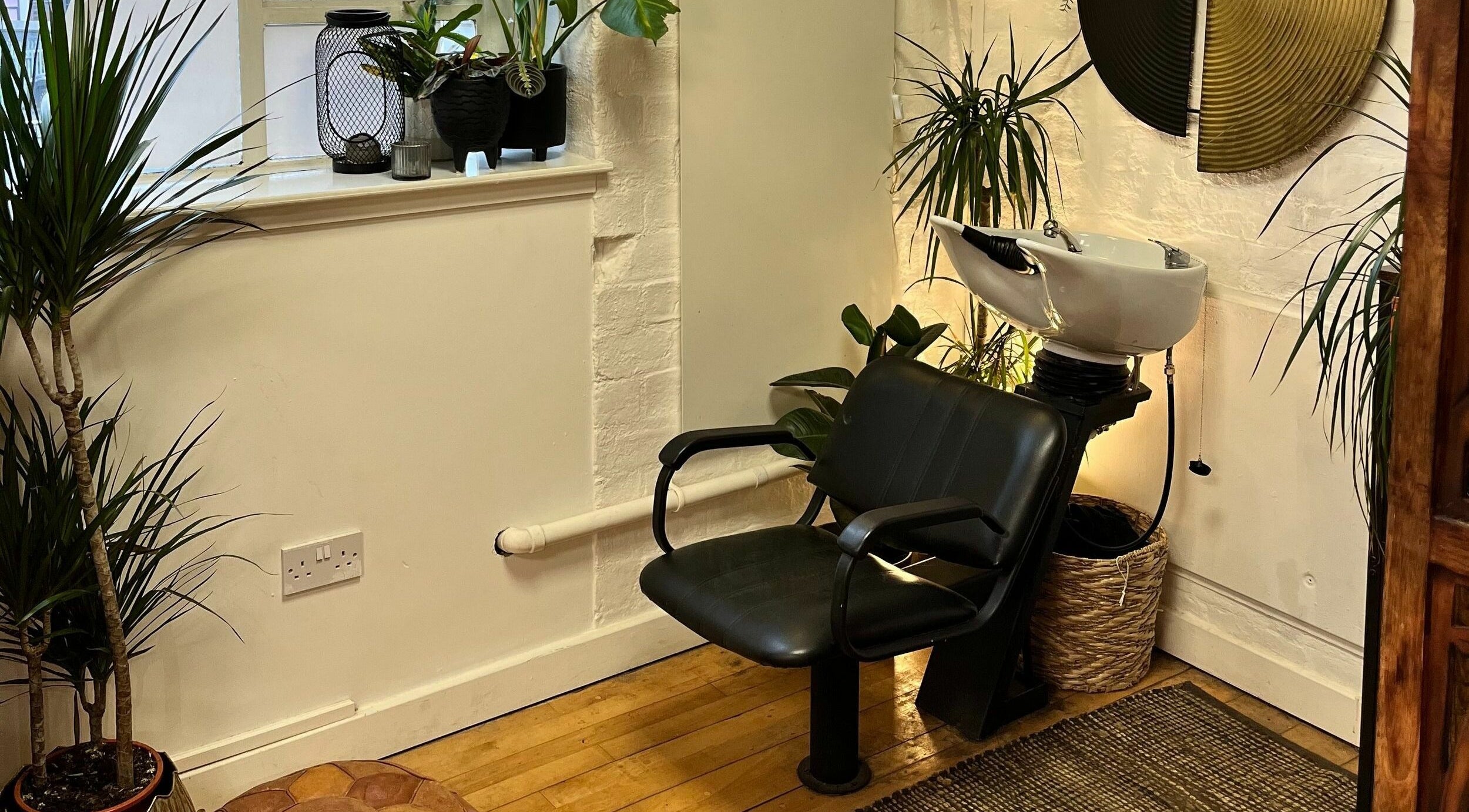 Stylish waiting area at Sheep Hair, Glasgow, Scotland, GB with lush plants and elegant decor.