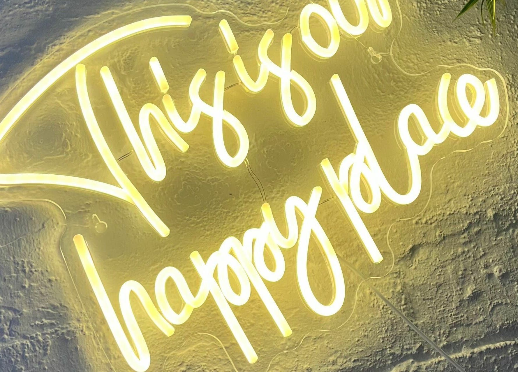 Neon sign 'This is our happy place' at Sheep Hair, Glasgow, Scotland, GB, creating a welcoming ambiance.