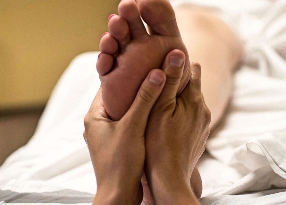 Reflexology session at Wellbeing and Healing with Lisa, Birkenhead, England, GB. Hands massaging a foot.