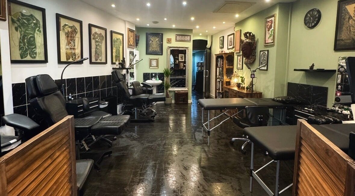 Interior of Black Dragon Tattoo Studio in Newton Abbot, England, GB, showcasing sleek design and art-filled walls.