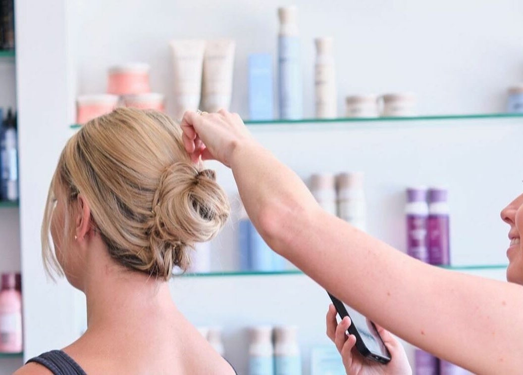 Hairstylist at NUHAIRCO in Mount Claremont creating a chic updo for a client.