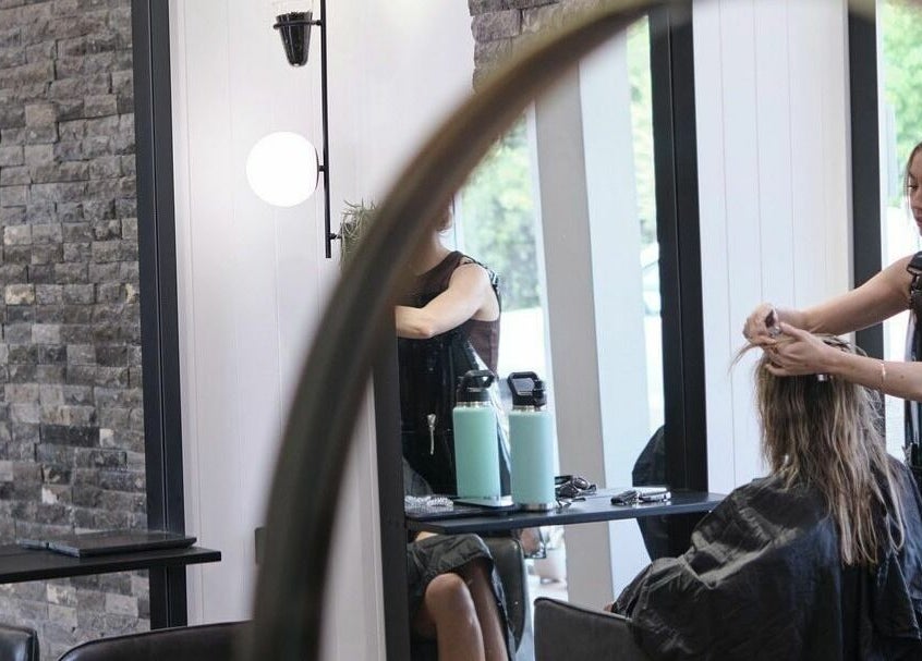 Professional stylist at NUHAIRCO in Mount Claremont, AU, expertly crafting a client's hairstyle.